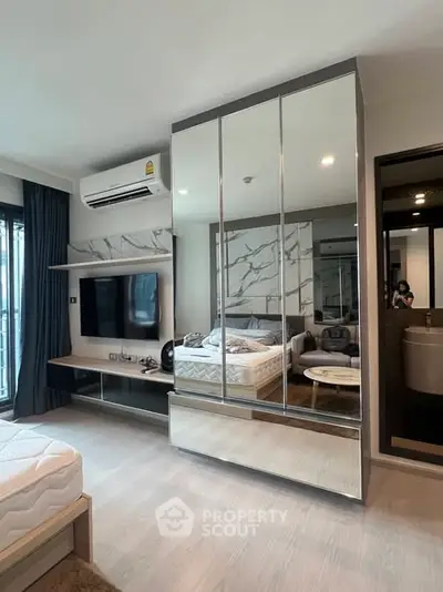 Modern bedroom with mirrored wardrobe and stylish decor in a contemporary apartment.