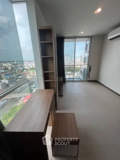 Modern high-rise apartment with stunning city view and balcony access.