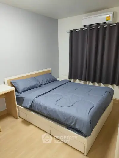 Cozy bedroom with modern furnishings and air conditioning, perfect for comfort and relaxation.