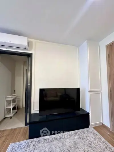Modern living room with sleek TV setup and air conditioning unit