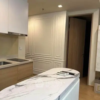Modern kitchen with marble countertop and sleek cabinetry in a stylish apartment.