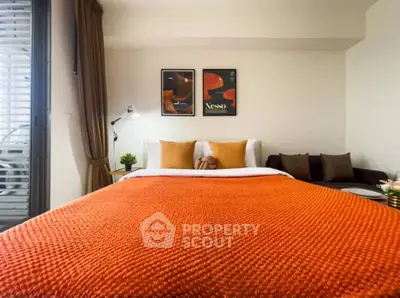 Cozy bedroom with vibrant orange bedding and stylish decor