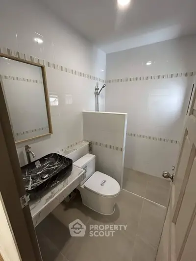 Modern bathroom with sleek black marble sink and contemporary fixtures.