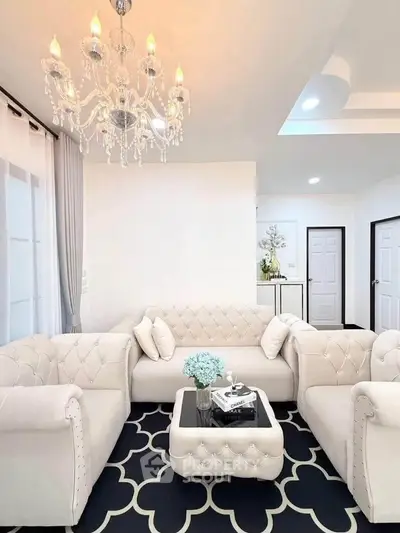 Elegant living room with plush white sofas, chic chandelier, and stylish decor in a modern home.