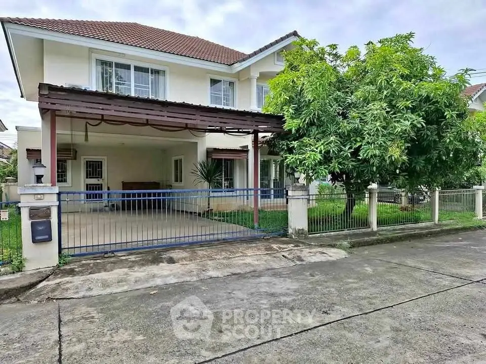 Charming two-story house with spacious driveway and lush garden in suburban neighborhood.