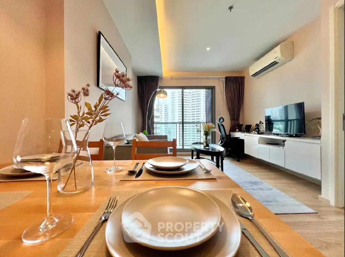 Modern living room with dining area and city view, featuring elegant decor and ample natural light.