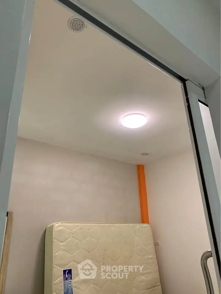 Compact bedroom with mattress and modern lighting, ideal for cozy living.