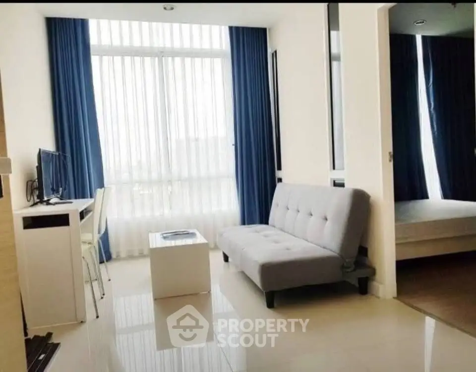 Modern living room with sleek furniture and large window, perfect for urban living.