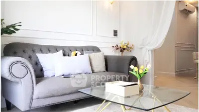 Elegant living room with stylish gray sofa and glass coffee table