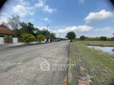 Scenic suburban street view with clear skies and lush greenery, perfect for tranquil living.