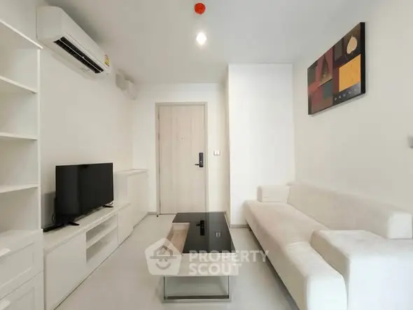 Modern living room with sleek white furniture and wall-mounted air conditioner