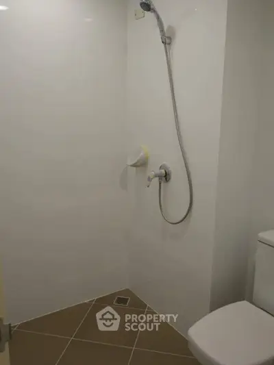 Minimalist bathroom with shower and toilet in modern apartment.