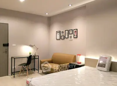 Modern bedroom with stylish decor, featuring a cozy sofa and workspace, perfect for urban living.