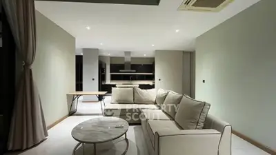 Spacious modern living room with elegant sofa and open kitchen layout