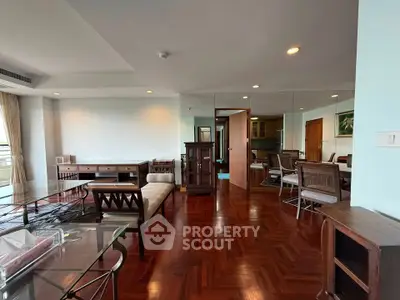 Spacious living room with elegant wooden flooring and stylish furniture, perfect for modern living.