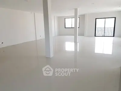 Spacious open-plan interior with large windows and balcony access
