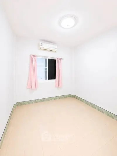 Bright empty room with air conditioning and tiled floor, ready for customization.