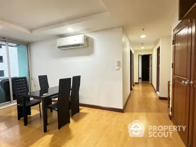 Spacious dining area in modern apartment with wooden flooring and air conditioning