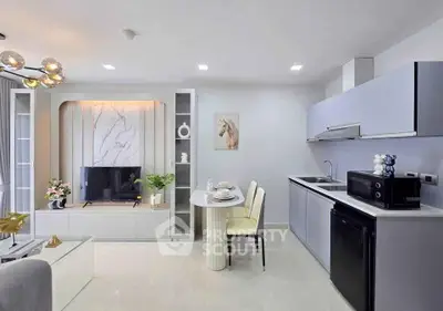 Modern open-layout living room and kitchen with sleek design and elegant decor.