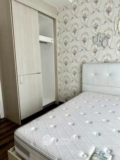 Charming bedroom with floral wallpaper and modern wardrobe, featuring a comfortable mattress for a cozy retreat.