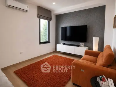 Modern living room with orange sofa, large TV, and stylish decor