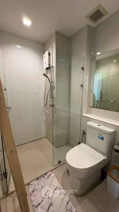 Modern bathroom with glass shower enclosure and sleek fixtures