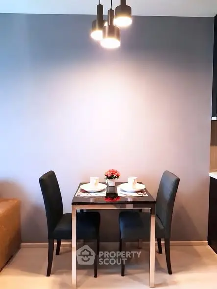 Modern dining area with sleek table and chairs under stylish lighting, perfect for cozy meals.