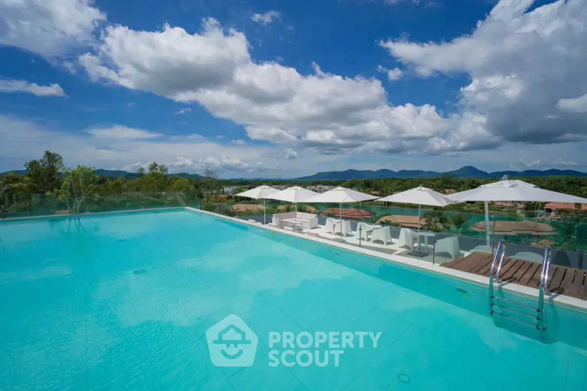Luxurious rooftop infinity pool with stunning mountain views and elegant poolside seating.