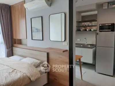 Modern studio apartment with cozy bedroom and compact kitchen area.
