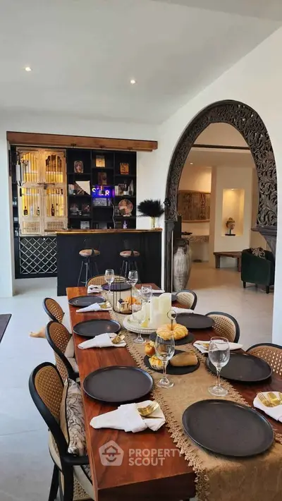 Elegant dining room with a stylish bar and intricate archway, perfect for entertaining guests.