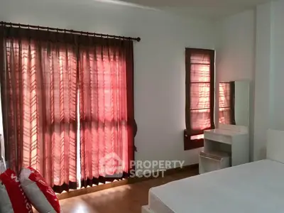 Spacious bedroom with large windows and elegant curtains, perfect for natural light lovers.