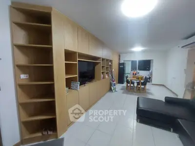 Spacious living room with built-in wooden shelves and modern furniture
