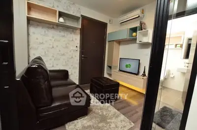 Modern living room with stylish decor and compact design, featuring a cozy leather sofa and wall-mounted TV.