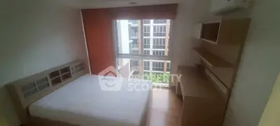 Cozy bedroom with large window and modern furniture in urban apartment