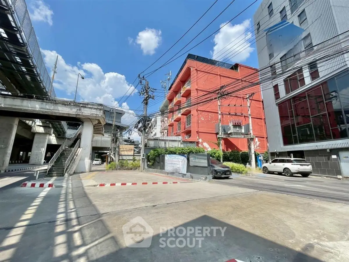 Urban street view with modern buildings and clear blue sky, showcasing vibrant city life.