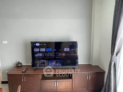 Modern living room with sleek TV setup and wooden cabinet
