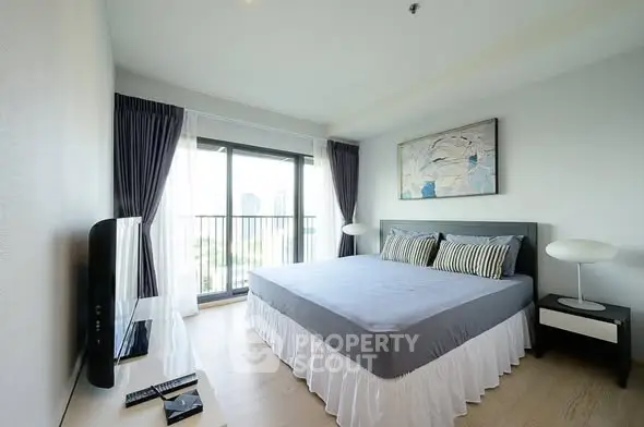Modern bedroom with large window and stylish decor in a high-rise apartment.