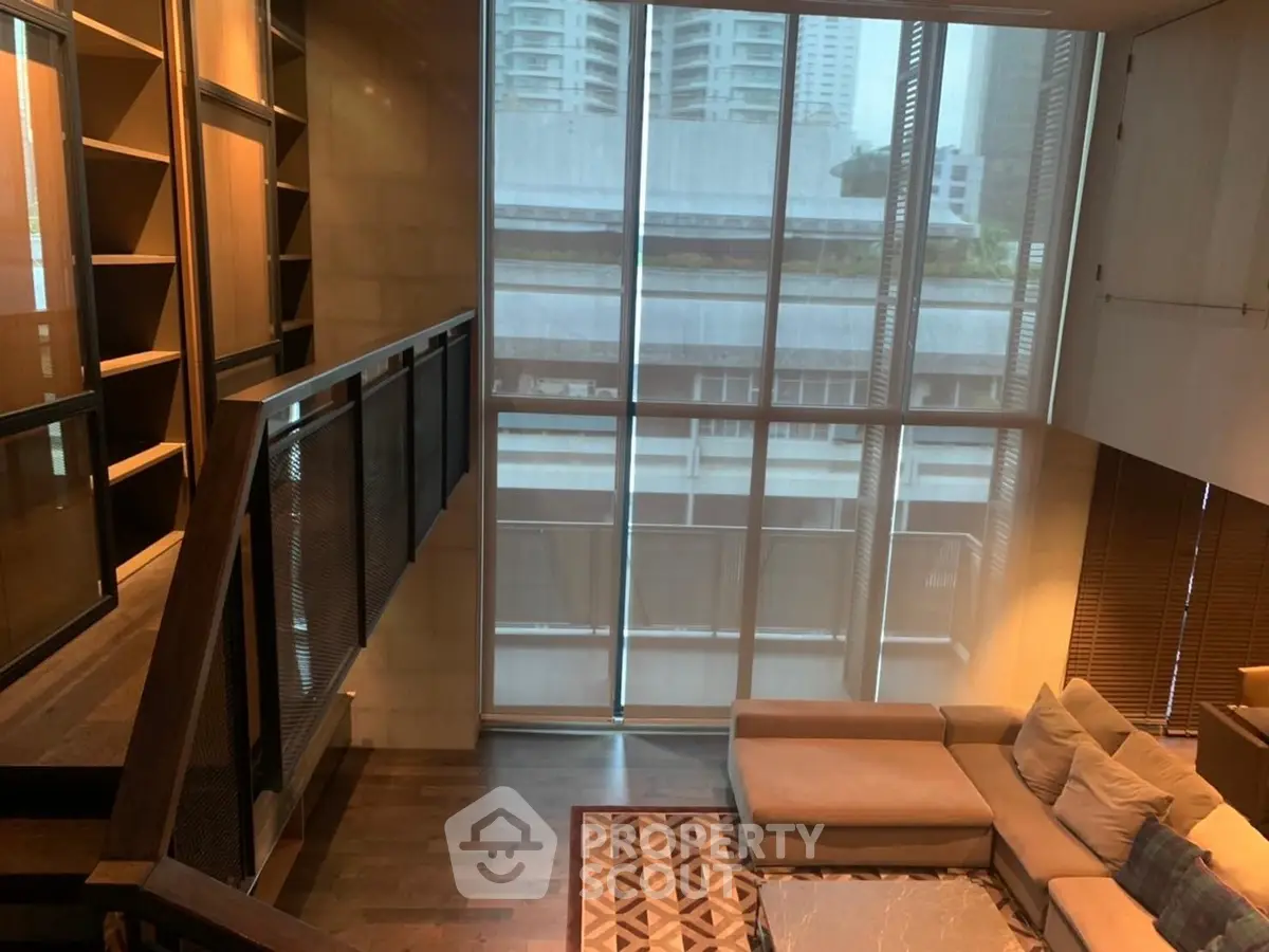 Luxurious living room with floor-to-ceiling windows and modern staircase in urban apartment.