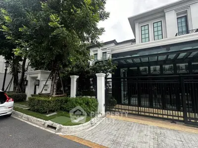 Elegant modern house with lush greenery and secure gated entrance