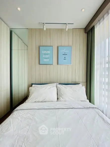 Modern bedroom with stylish decor and large window offering natural light.