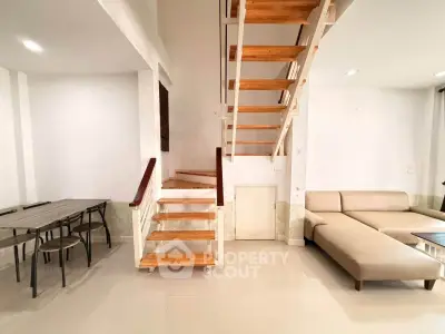 Modern living room with stylish staircase and cozy seating area
