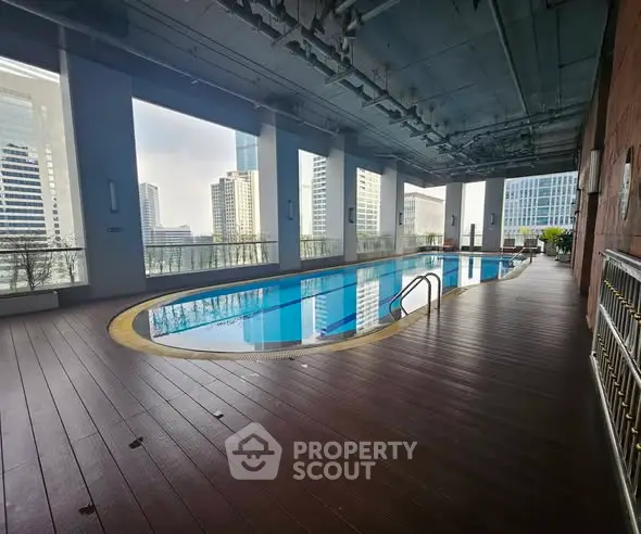 Luxurious rooftop pool with stunning city views in modern high-rise building.