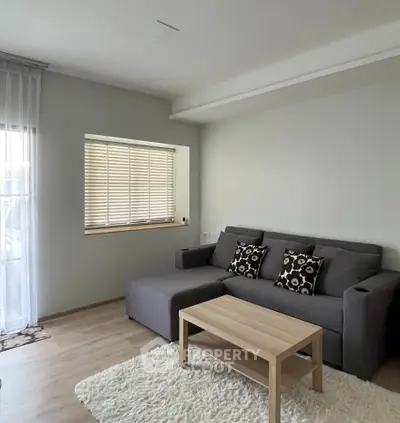 Cozy living room with modern gray sofa and wooden coffee table, perfect for relaxation.