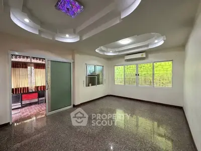 Spacious living room with modern ceiling design and large windows for natural light.