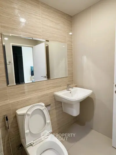Modern bathroom with sleek fixtures and neutral tiles, perfect for a contemporary home.