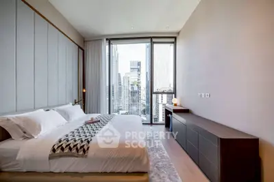 Luxurious bedroom with city view, modern decor, and elegant furnishings.