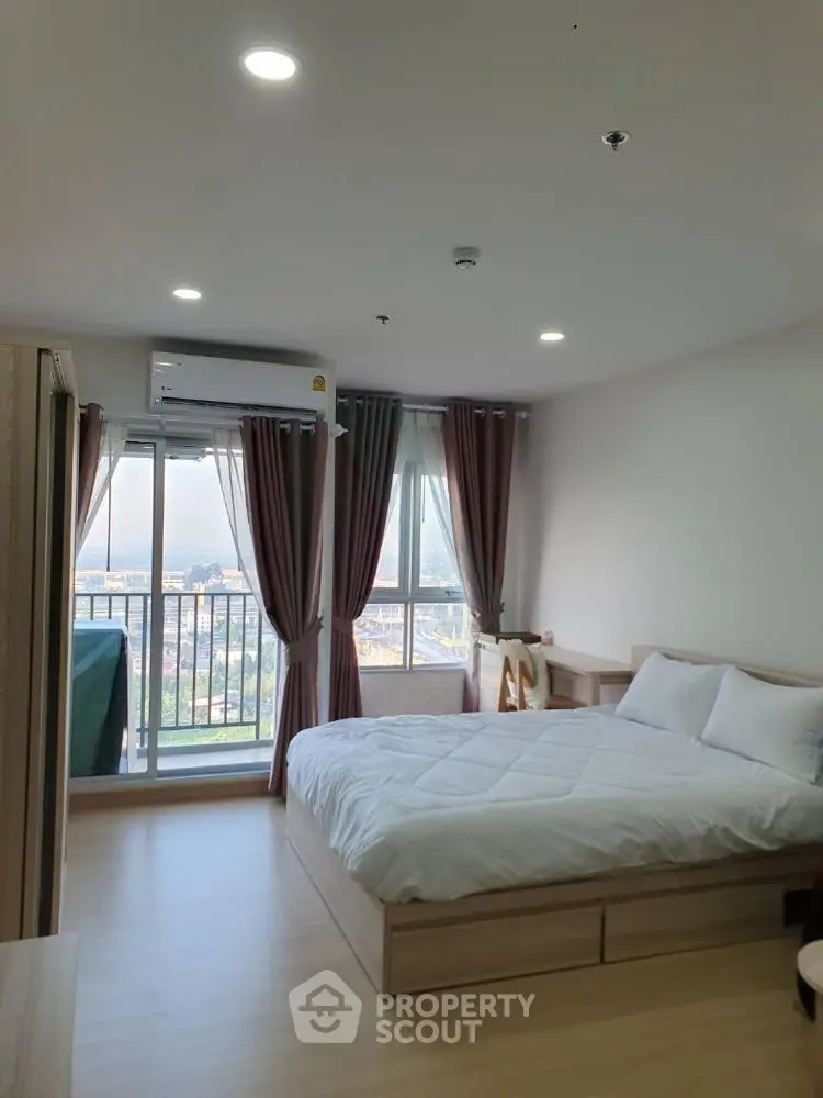 Spacious bedroom with balcony and city view in modern apartment
