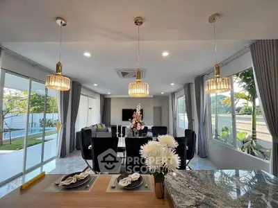 Luxurious open-plan living room with elegant decor and pool view, perfect for modern living.