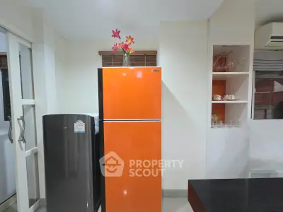 Modern kitchen with vibrant orange fridge and sleek design