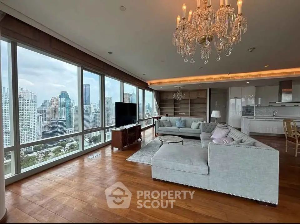 Luxurious corner unit living room with panoramic city views and elegant chandelier.